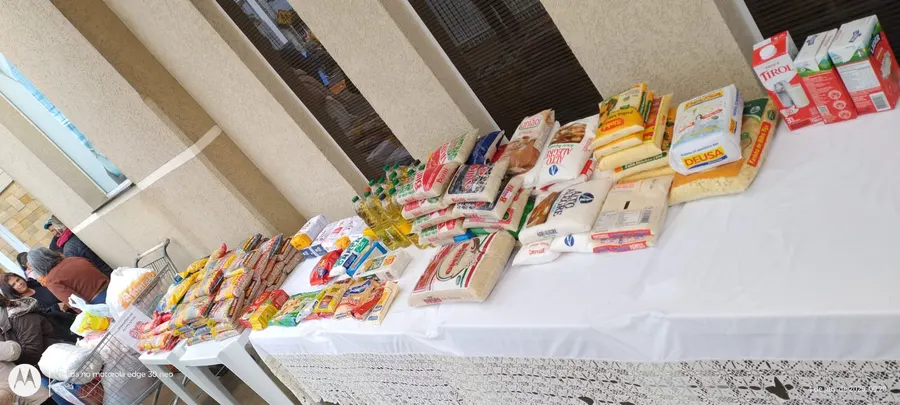 Mesa com alimentos doados pela comunidade — arroz, feijão, óleo e leite