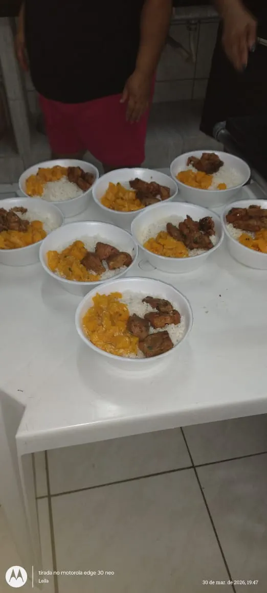 Marmitas prontas, com arroz, feijão e carne, organizadas para distribuição